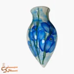 گلدان دیوارکوب قطره‌ای آبی مدل شبنم سرامیکی با گل‌های آبی روی زمینه‌ی آبرنگی آسمانی