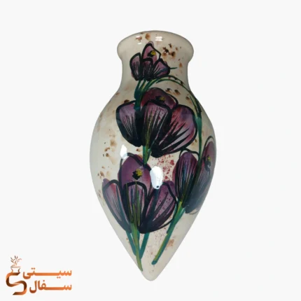 گلدان دیوارکوب قطره‌ای بنفش مدل شبنم سرامیکی با گل‌های بنفش و خط‌دور مشکی روی زمینه‌ی کرم
