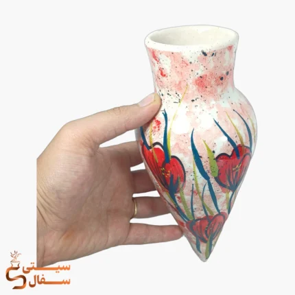 گلدان دیواری نارنجی سرامیکی مدل رویش با گل‌های نارنجی در دست